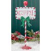 Red, Green and White Metal North Pole Sign on Stand
