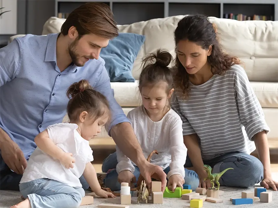A family playing on the floor with some blocks